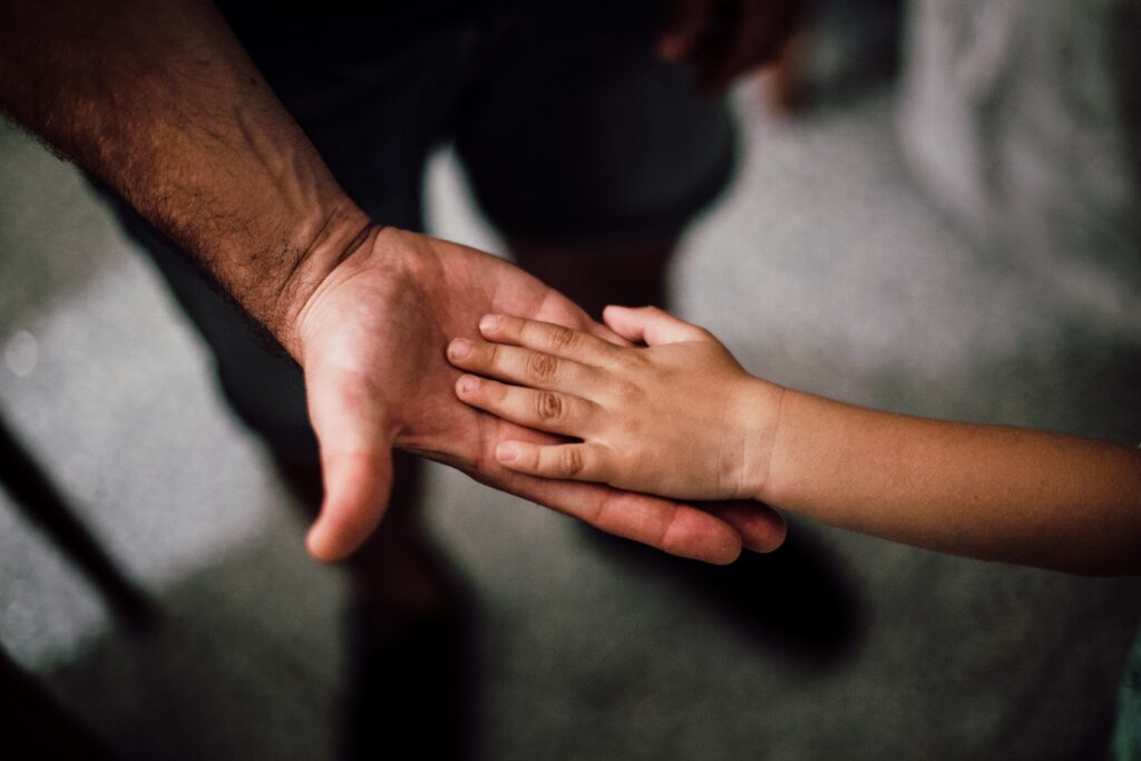 Main d'un père et celle de son enfant